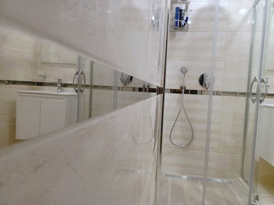 Bathroom with a shower enclosure and a wall-hung toilet — Shower enclosure and washbasin