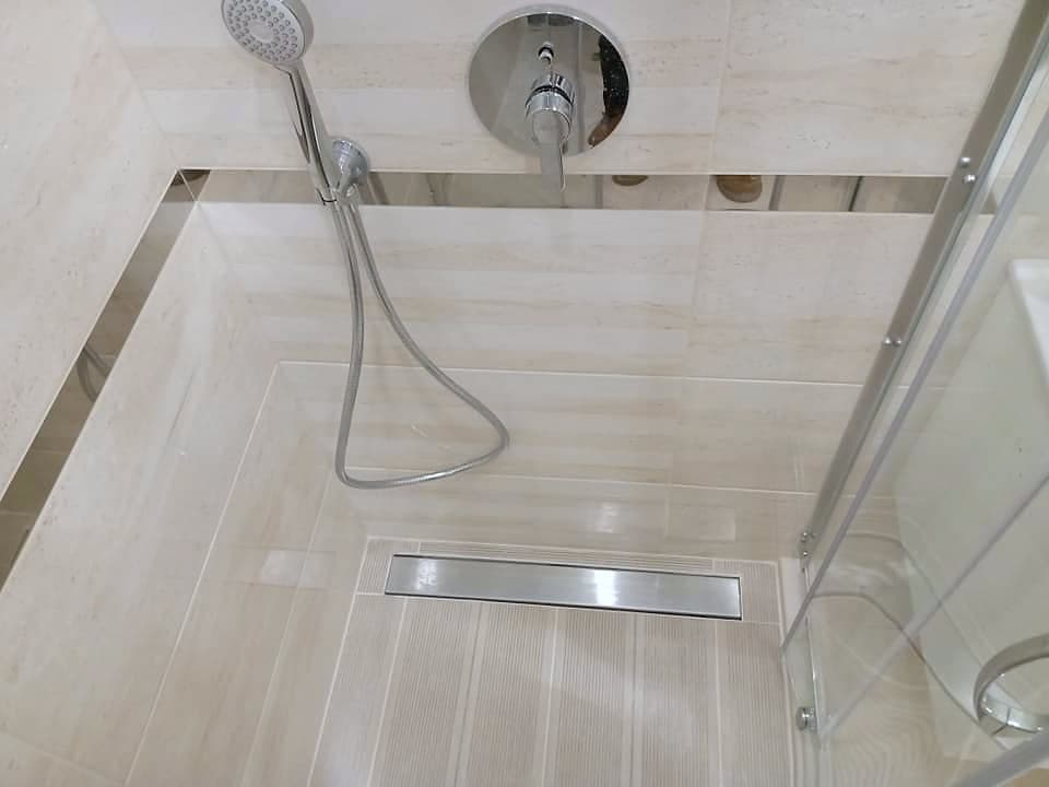 Bathroom with a shower enclosure and a wall-hung toilet — Concealed mixer and linear drain