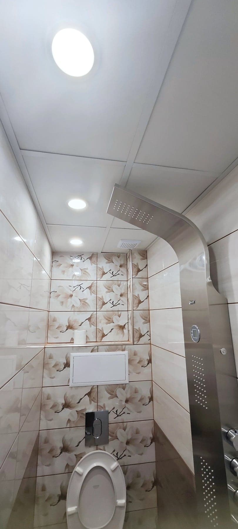 Bathroom with floral tiles and a shower panel — Shower panel and floral tiles