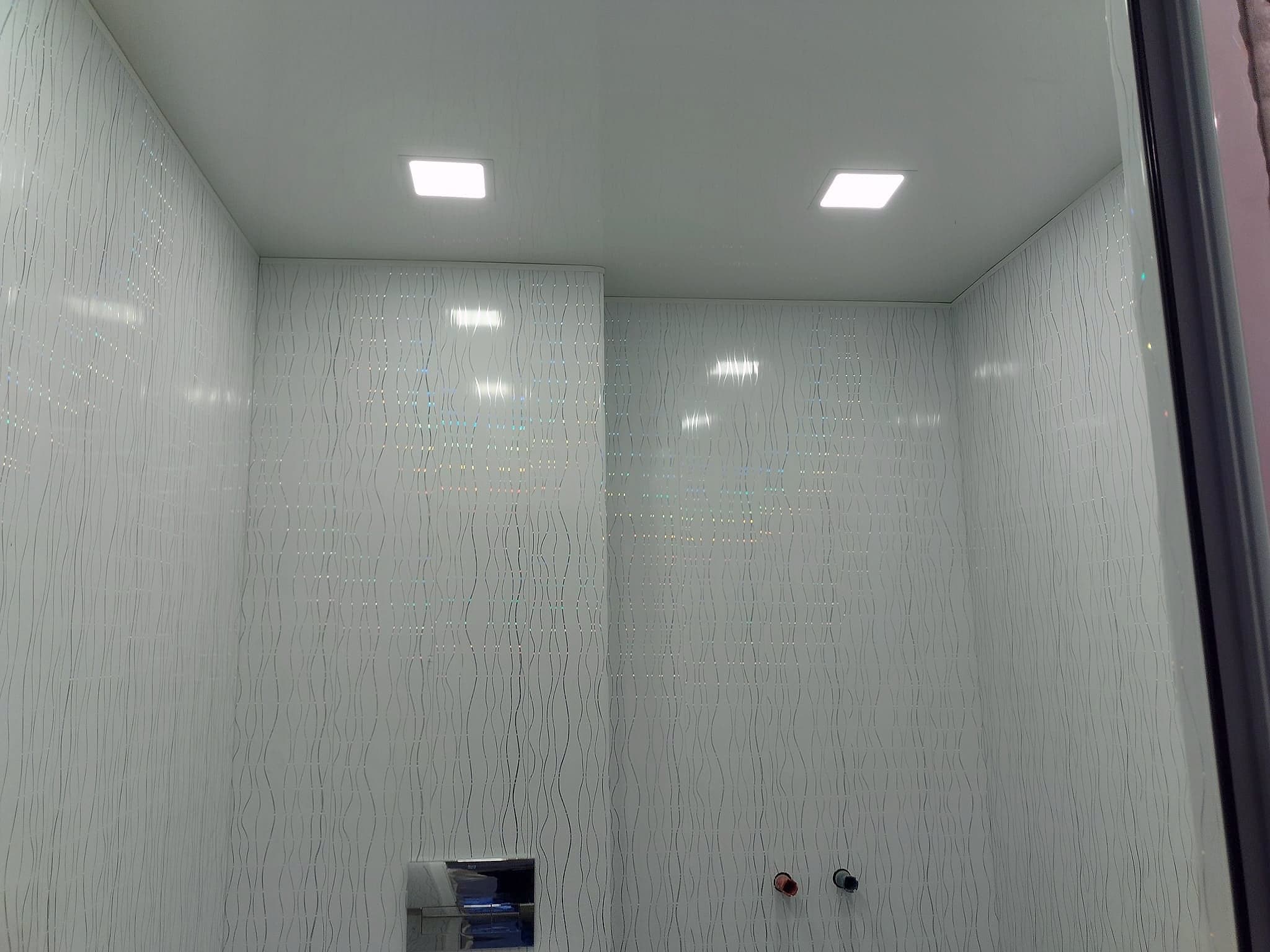 Bathroom with a wall-hung toilet and textured tiles — White textured wall tiles