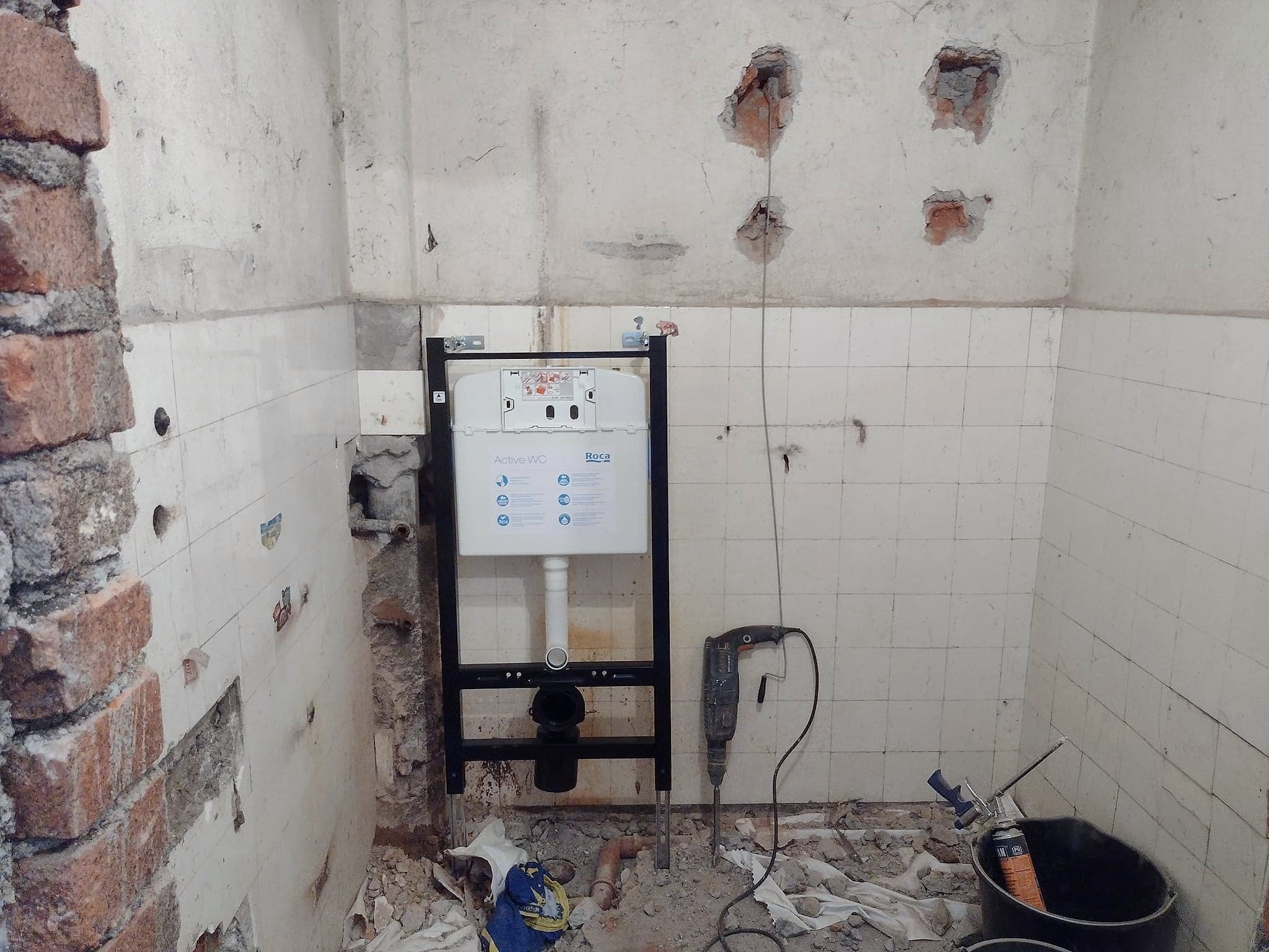 Bathroom with a wall-hung toilet and textured tiles — Before and after the tiling