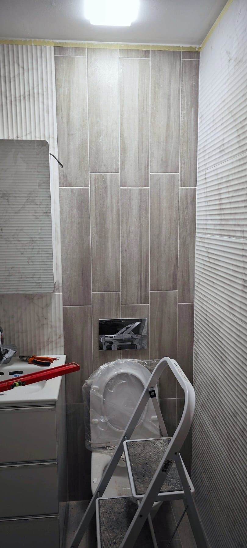Bathroom with wood-effect and white textured tiles — During the renovation