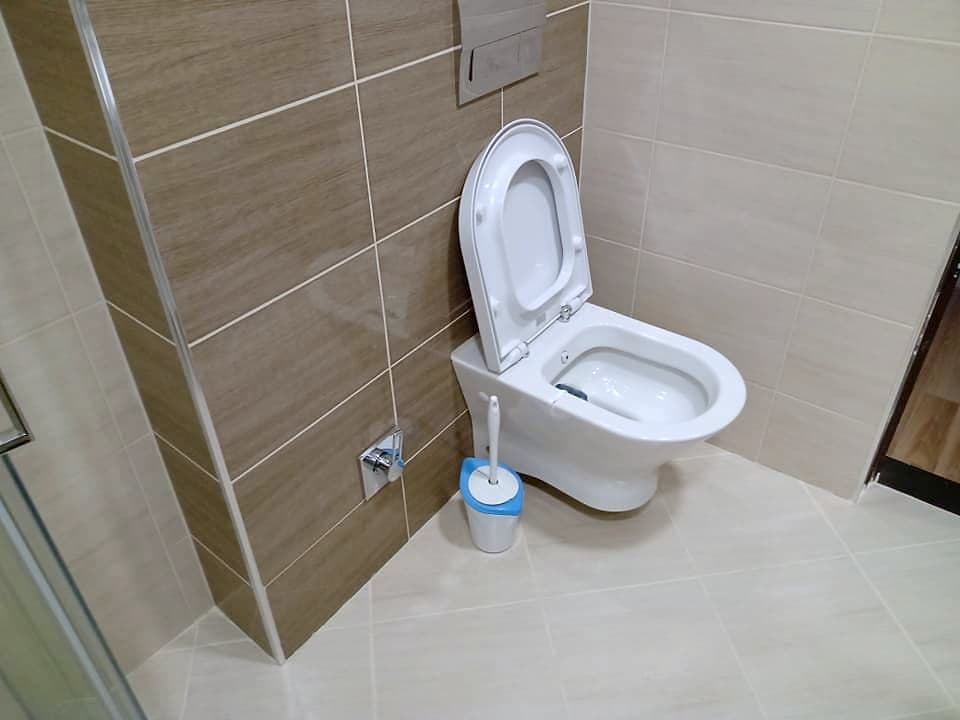 Beige and brown bathroom with a shower enclosure — Wall-hung toilet