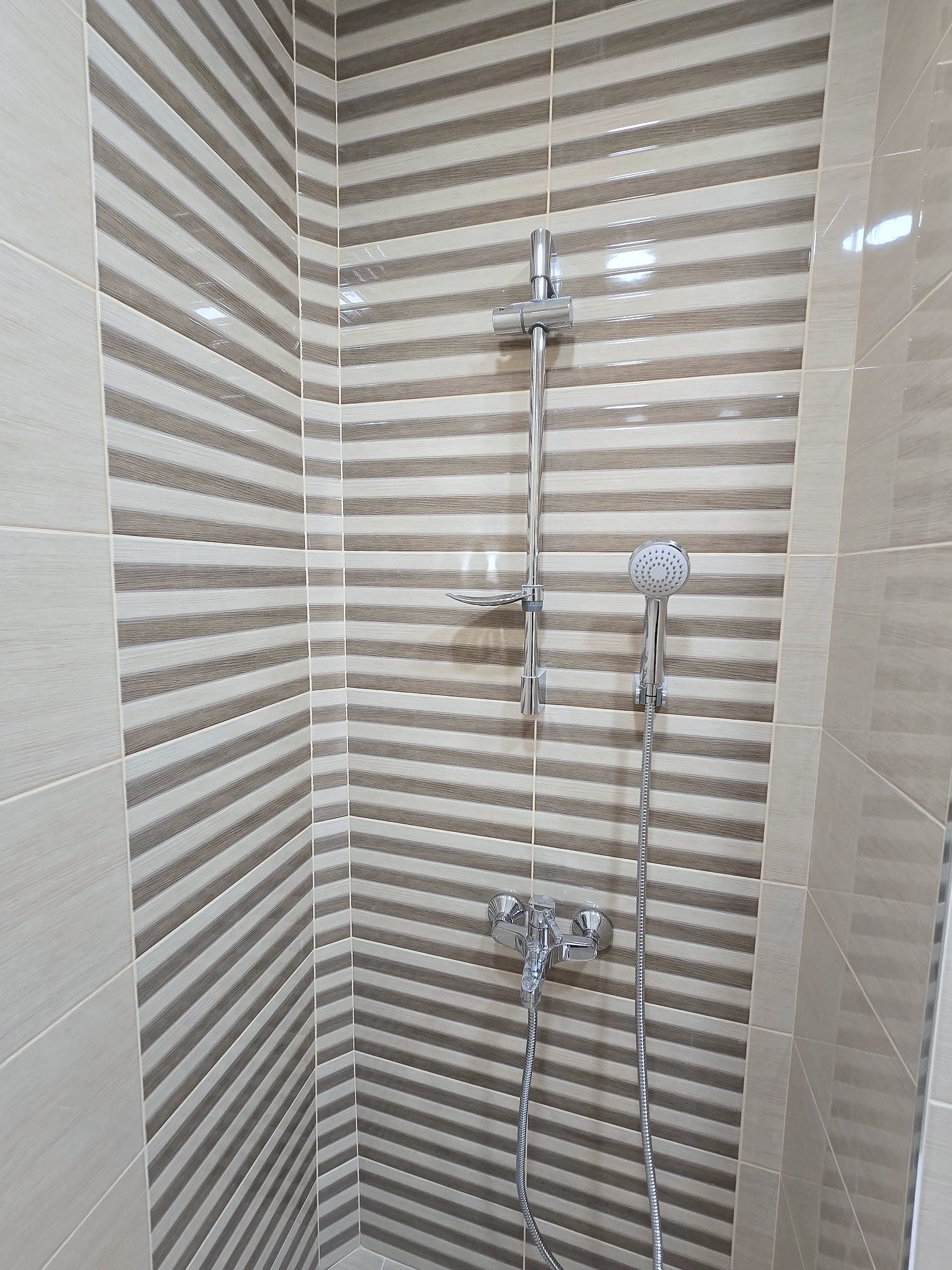 Bathroom in Sveta Troitsa: beige with a wood-effect floor — Shower area with decorative stripes