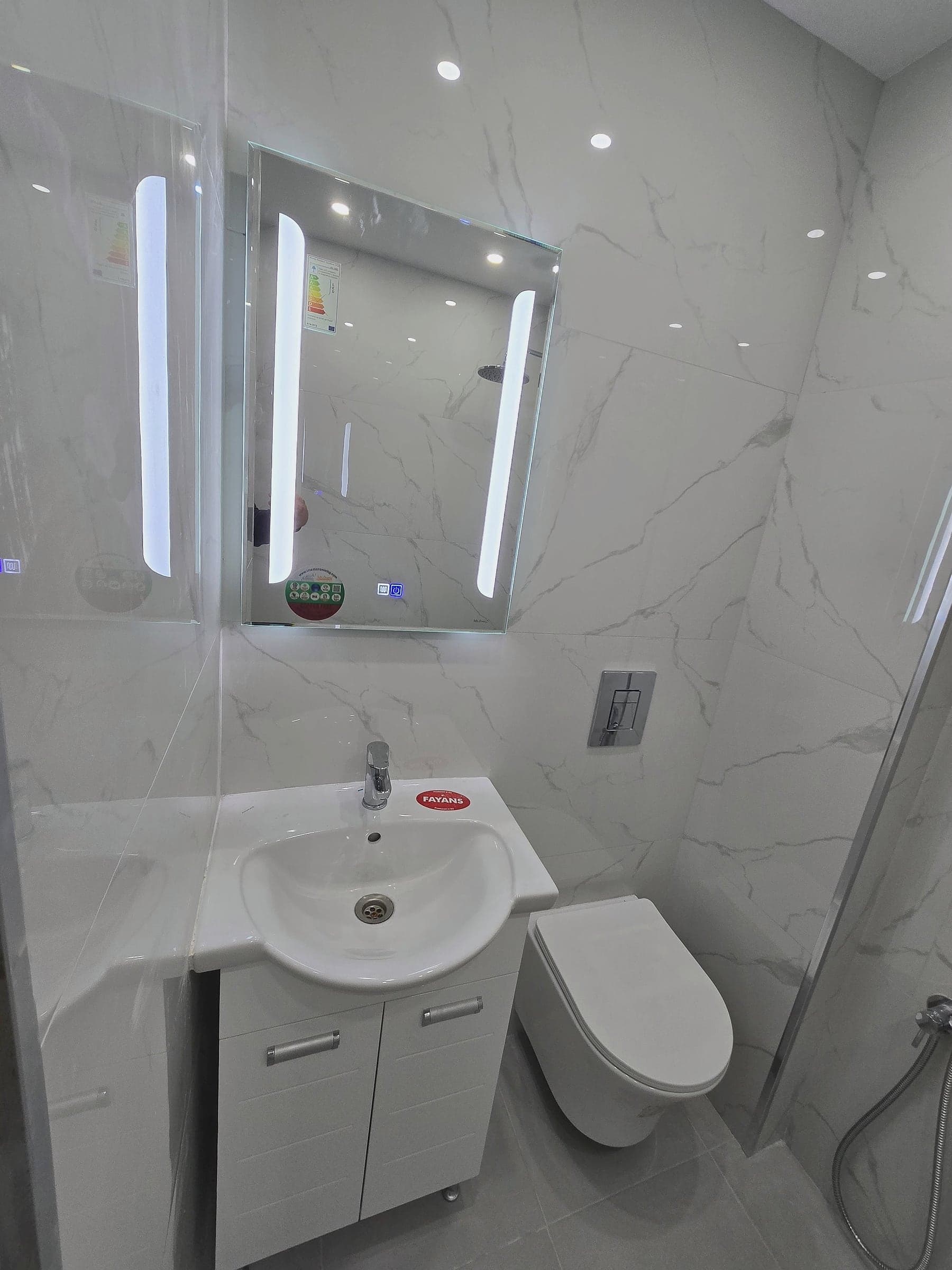 Bathroom in Gotse Delchev: white marble and an LED mirror — Washbasin and illuminated mirror