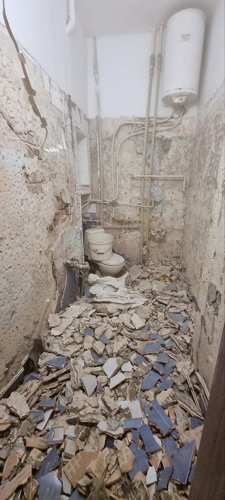 White and grey marble bathroom with black taps — Before the renovation: removing the old tiles