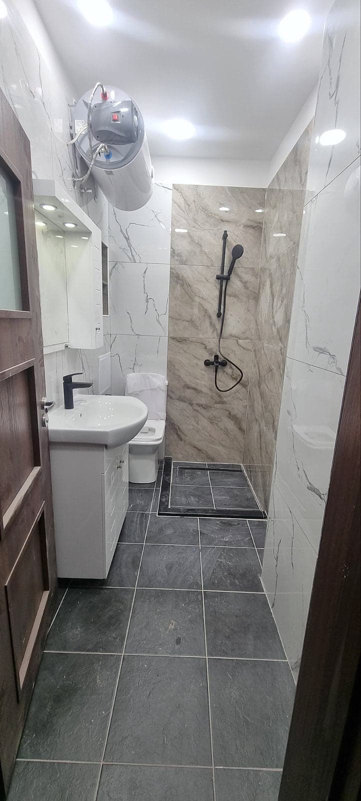 White and grey marble bathroom with black taps — The bathroom before and after the renovation