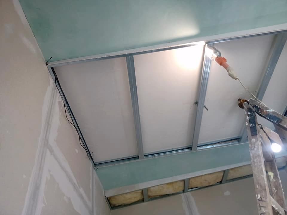 Living room with a suspended ceiling and LED lighting — The ceiling frame during the renovation