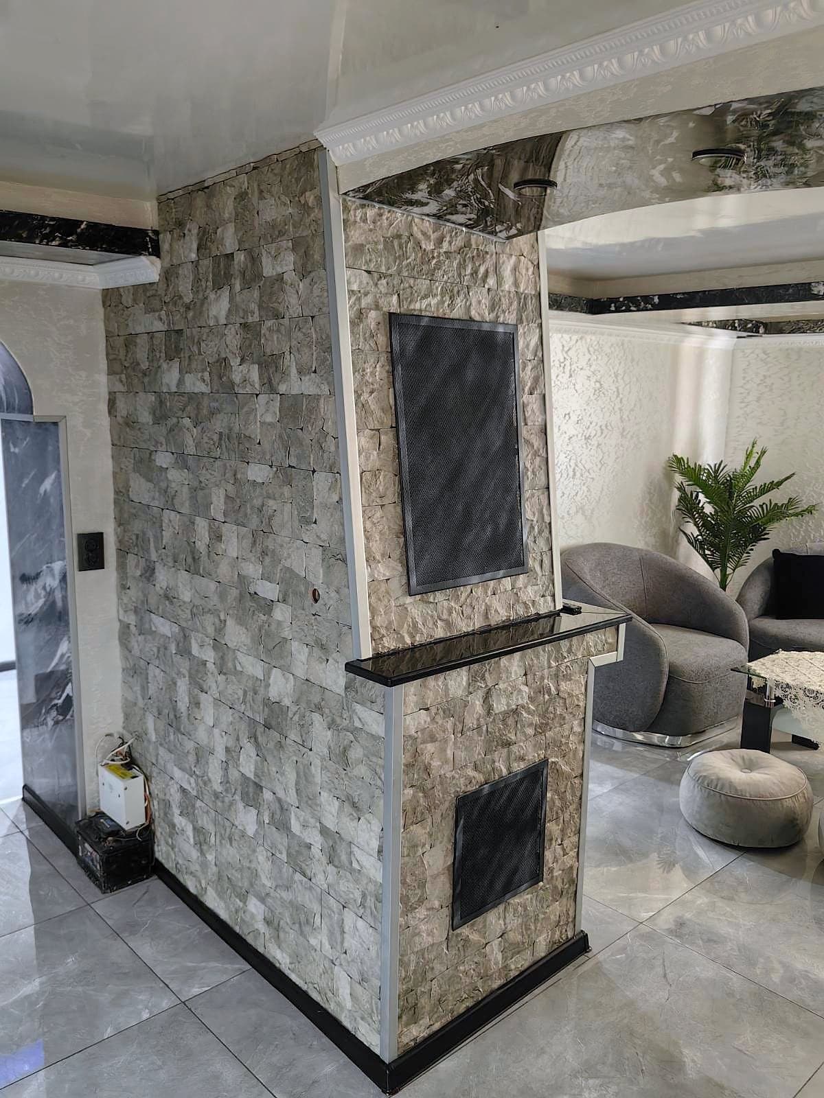 House with decorative ceilings, walls and arches — Living room with a column clad in stone-effect tiles