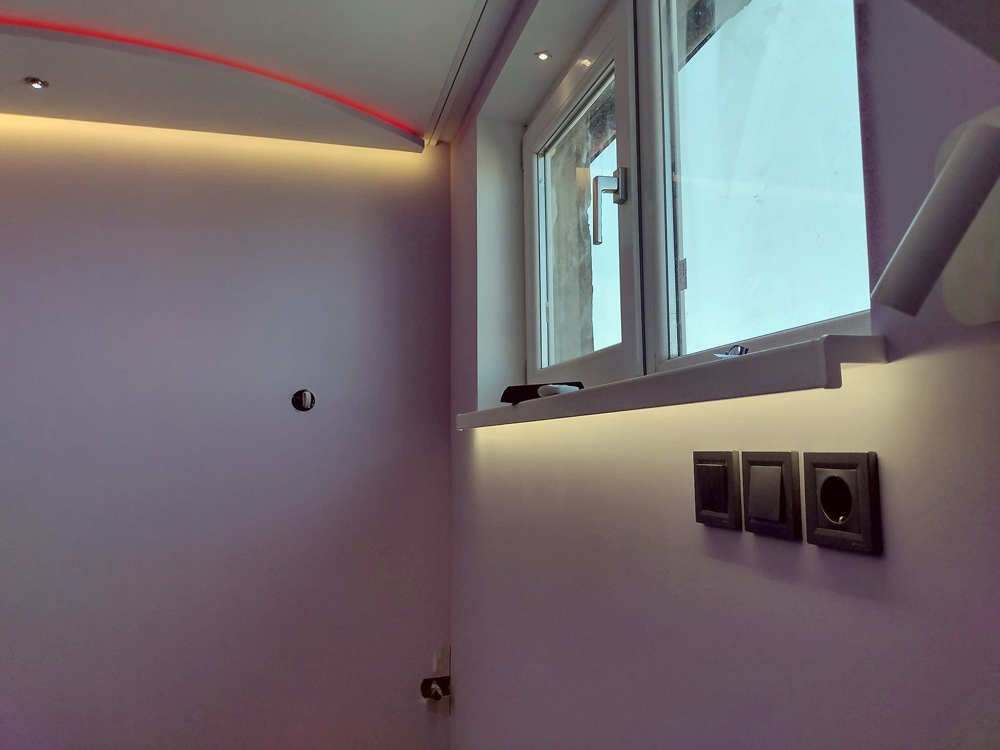 Attic room with a suspended ceiling and LED lighting — LED lighting above the window