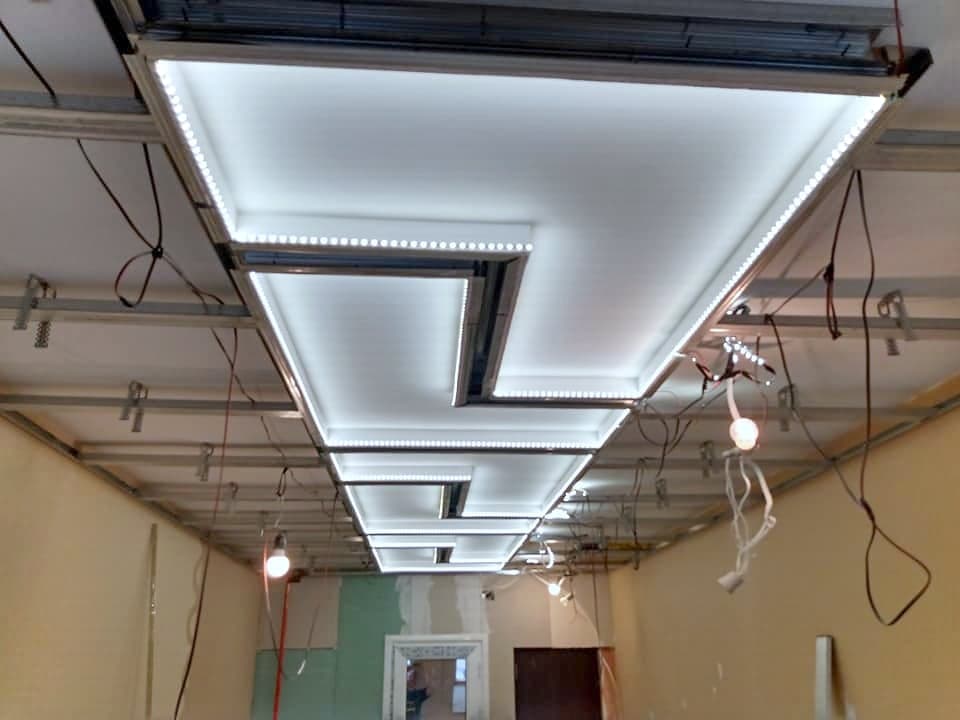 Ceiling with geometric LED lighting — The illuminated panels during installation