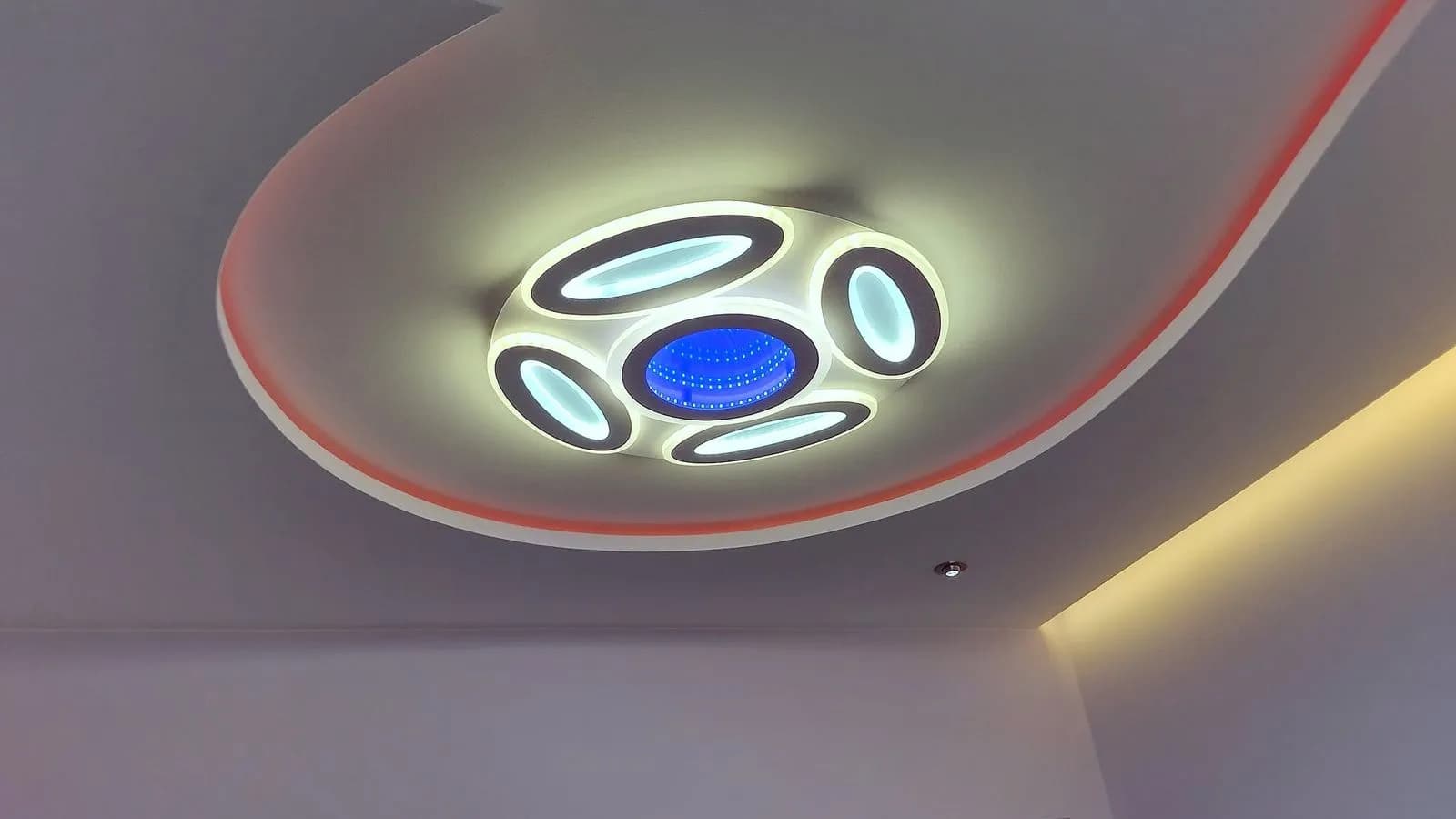 Окачен таван с извита форма и скрито LED осветление в мансардна стая